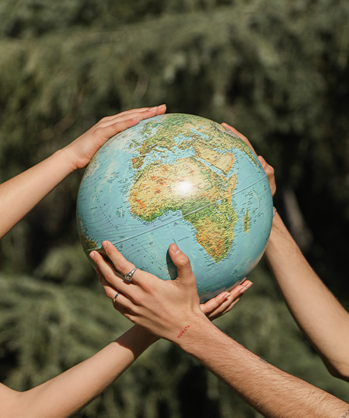 Två händer håller i en jordglob