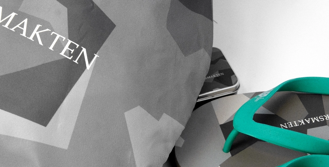 N&auml;rbild p&aring; F&ouml;rsvarsmaktens merchandise, inklusive flip-flops med turkosa remmar och tyg, som alla har ett gr&aring;tt kamouflage-/geometriskt m&ouml;nster