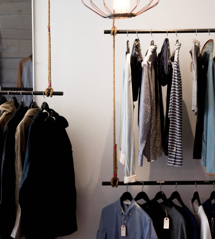 Herr- och damtr&ouml;jor som h&auml;nger p&aring; en kl&auml;dh&auml;ngare i en butik.